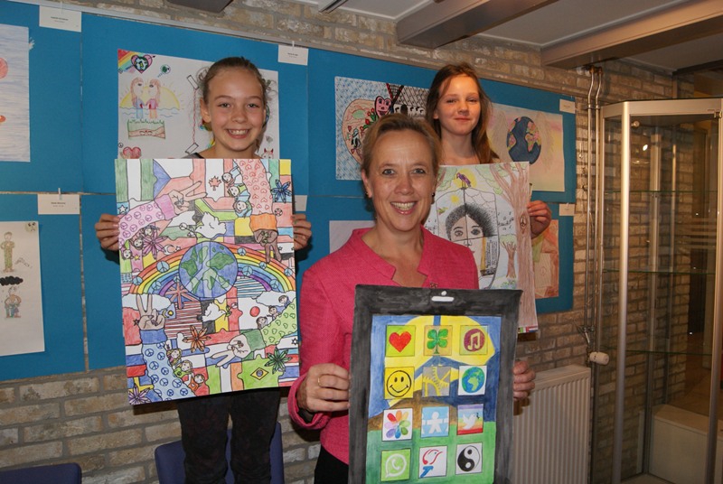Vlnr winnares Rosalie Mondon, wethouder Nieuwenhuizen met de tekening van Norah en Jasmijn Mulder met haar kunstwerk. 